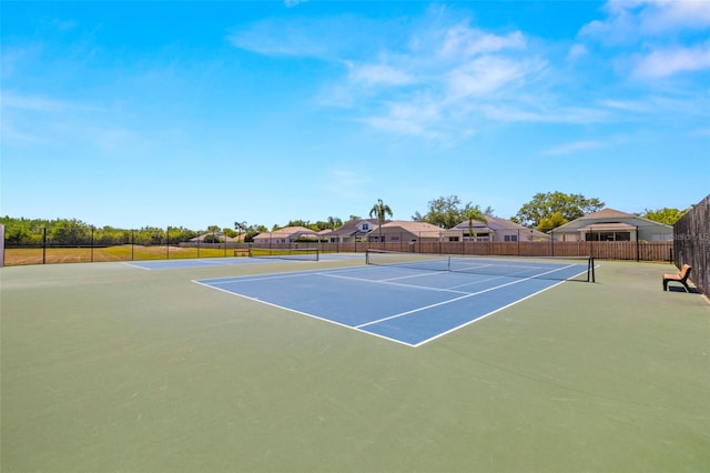 view of tennis court featuring fence