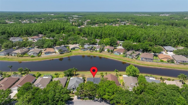 drone / aerial view featuring a wooded view and a residential view