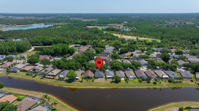 drone / aerial view featuring a water view, a view of trees, and a residential view