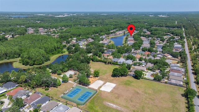 aerial view featuring a water view, a view of trees, and a residential view