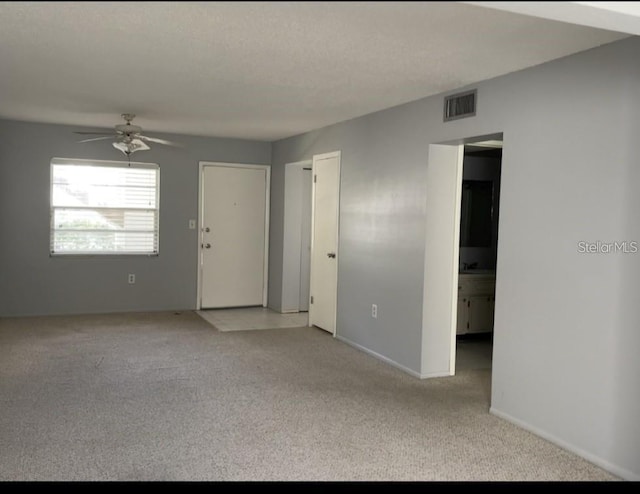 1975 W Bay Dr Unit 207, Largo, FL 33770 - spare room featuring light colored carpet, a ceiling fan, baseboards, and visible vents