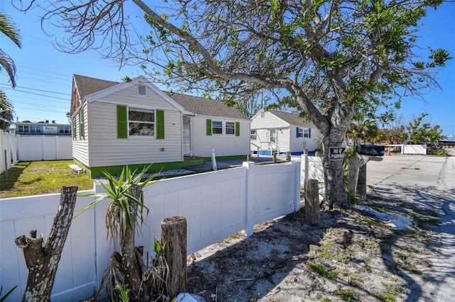 103 146th Ave E, Madeira Beach, FL 33708 - exterior space featuring a shingled roof and a fenced front yard