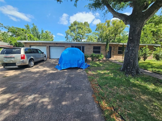 3714 E Ellicott St, Tampa, FL 33610 - ranch-style house with an attached garage, brick siding, and driveway