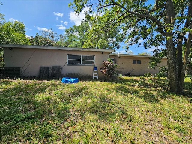 3714 E Ellicott St, Tampa, FL 33610 - rear view of house with central air condition unit, a lawn, stucco siding, and fence