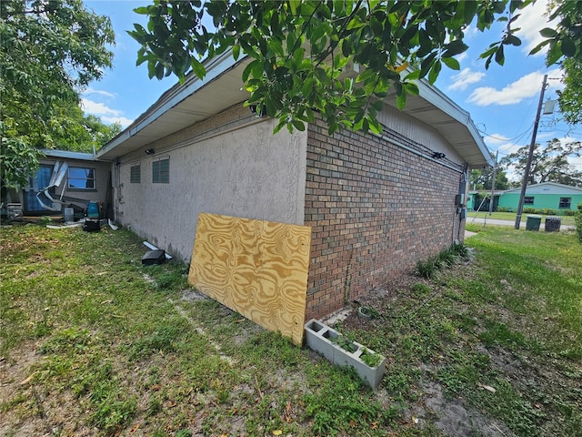 3714 E Ellicott St, Tampa, FL 33610 - view of home's exterior featuring brick siding, a yard, and stucco siding