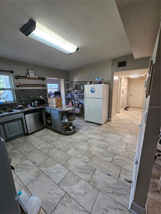 3714 E Ellicott St, Tampa, FL 33610 - kitchen featuring a healthy amount of sunlight, open shelves, visible vents, and freestanding refrigerator