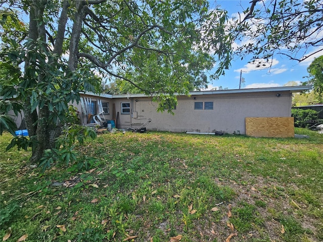 3714 E Ellicott St, Tampa, FL 33610 - rear view of property with stucco siding and a yard