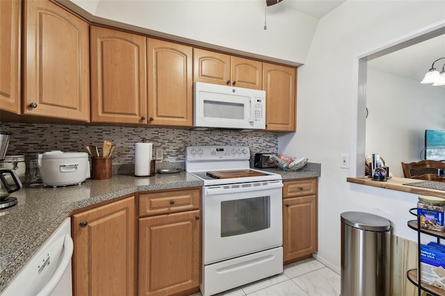 9945 47th Ave N Unit 208, Saint Petersburg, FL 33708 - kitchen with white appliances, backsplash, and dark countertops