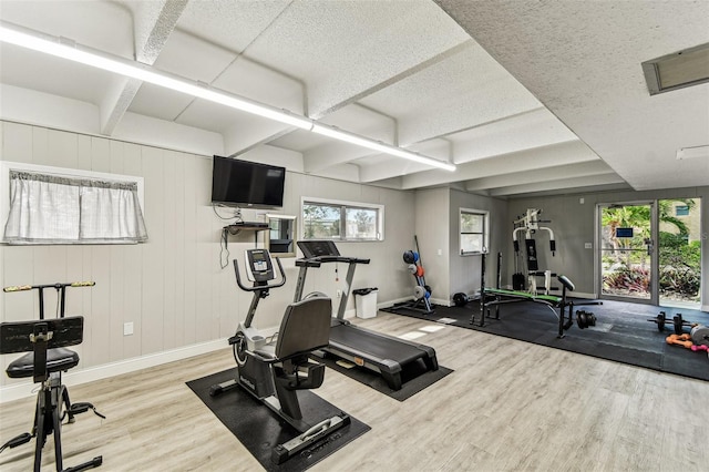 9945 47th Ave N Unit 208, Saint Petersburg, FL 33708 - workout area featuring baseboards, wood finished floors, plenty of natural light, and a textured ceiling