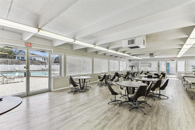 9945 47th Ave N Unit 208, Saint Petersburg, FL 33708 - dining room with wood finished floors, a textured ceiling, baseboards, beamed ceiling, and plenty of natural light