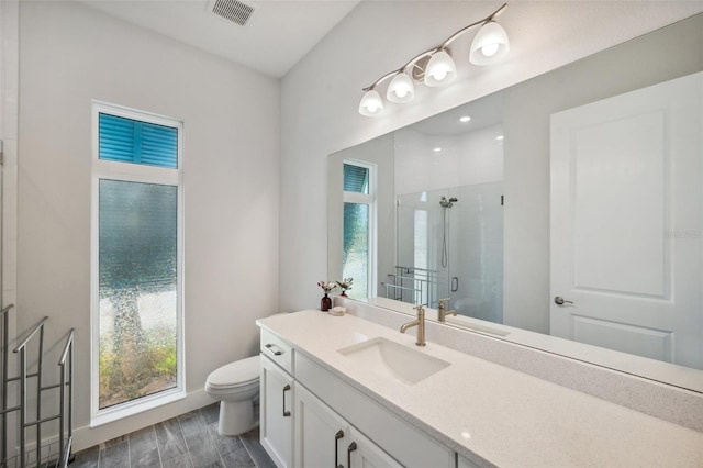 5917 Cat Claw Ln, Bradenton, FL 34210 - bathroom featuring toilet, a stall shower, visible vents, wood finished floors, and vanity