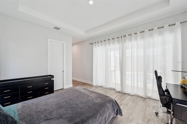 5917 Cat Claw Ln, Bradenton, FL 34210 - bedroom with a tray ceiling, visible vents, light wood finished floors, and baseboards