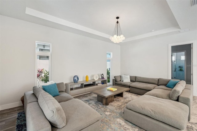 5917 Cat Claw Ln, Bradenton, FL 34210 - living area featuring a raised ceiling, wood finished floors, visible vents, baseboards, and a chandelier