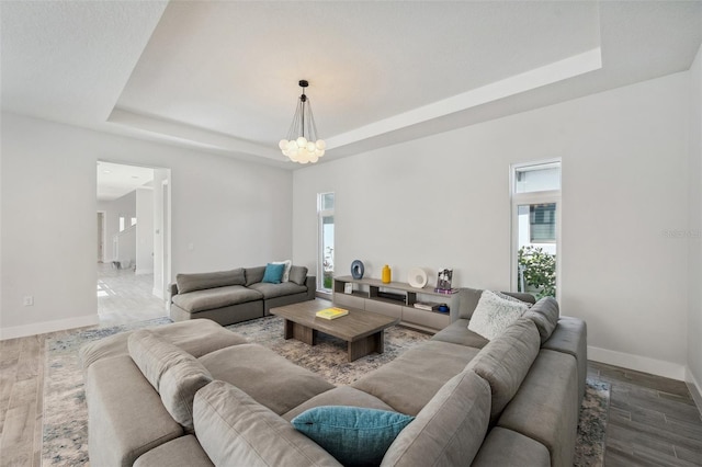 5917 Cat Claw Ln, Bradenton, FL 34210 - living room featuring baseboards, a notable chandelier, and a tray ceiling