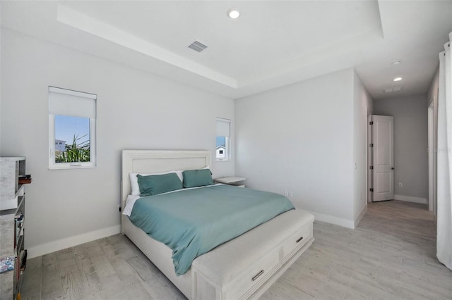 5917 Cat Claw Ln, Bradenton, FL 34210 - bedroom featuring light wood-type flooring, baseboards, visible vents, and a raised ceiling