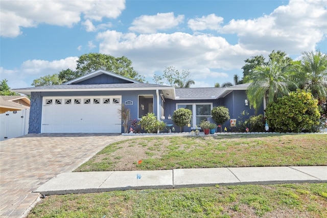 single story home featuring driveway, a front yard, and a garage