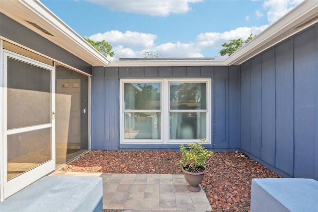 entrance to property featuring a patio and board and batten siding