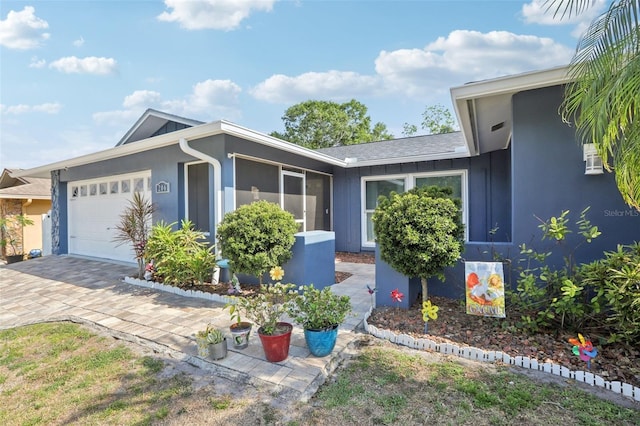 view of front of property with decorative driveway, a garage, and stucco siding
