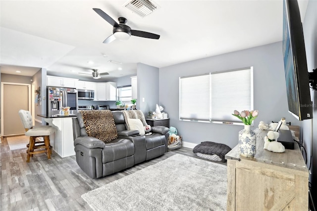 living room with recessed lighting, visible vents, ceiling fan, and light wood-style floors