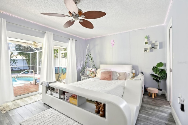 bedroom featuring access to exterior, ceiling fan, wood finished floors, and a textured ceiling
