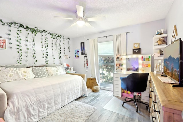 bedroom featuring a textured ceiling, a ceiling fan, and wood finished floors