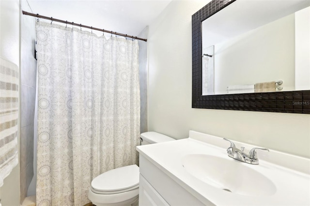 bathroom with curtained shower, toilet, and vanity