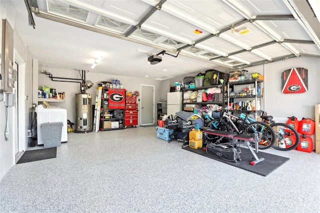garage with washer and dryer, a garage door opener, electric water heater, and freestanding refrigerator