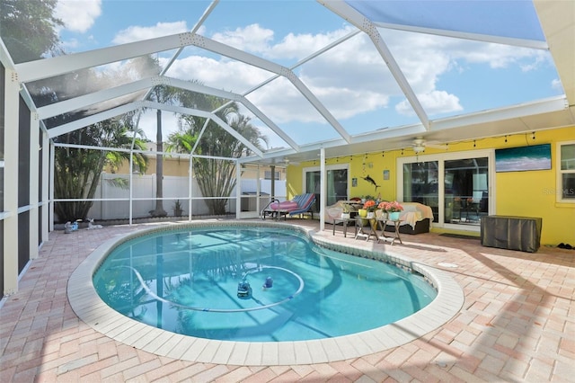 view of pool featuring a fenced in pool, a patio area, glass enclosure, fence, and a ceiling fan