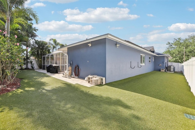 rear view of house featuring a lawn, stucco siding, a fenced backyard, and a patio area