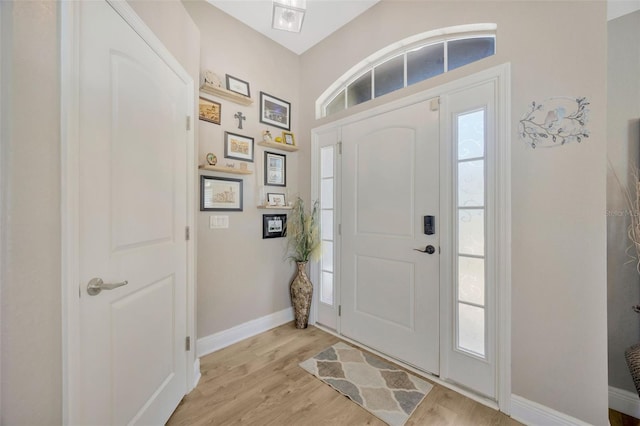 foyer with light wood finished floors and baseboards