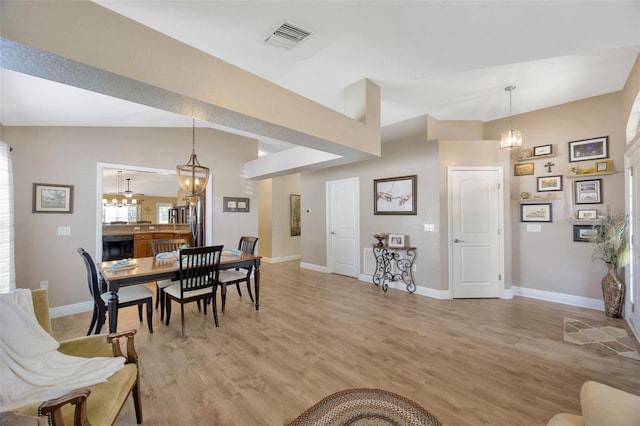 dining area featuring visible vents, light wood finished floors, and baseboards