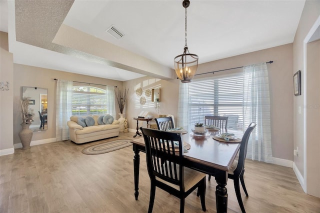 dining room with baseboards, an inviting chandelier, visible vents, and light wood-type flooring