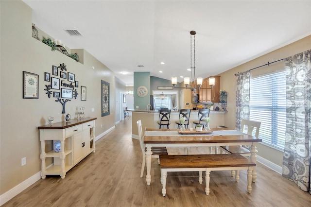 dining room featuring light wood-type flooring, vaulted ceiling, baseboards, recessed lighting, and visible vents