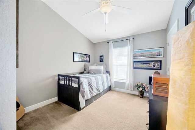 carpeted bedroom with vaulted ceiling, a ceiling fan, and baseboards