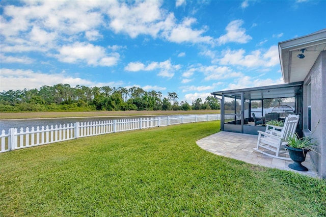 view of yard with a sunroom, a fenced backyard, a patio, and a water view