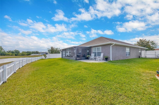 back of property featuring a yard, a sunroom, a fenced backyard, and stucco siding