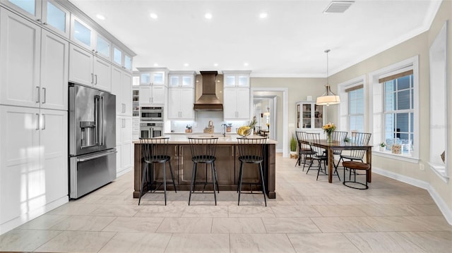 10101 Bryant Rd, Lithia, FL 33547 - kitchen with appliances with stainless steel finishes, custom exhaust hood, light countertops, plenty of natural light, and ornamental molding