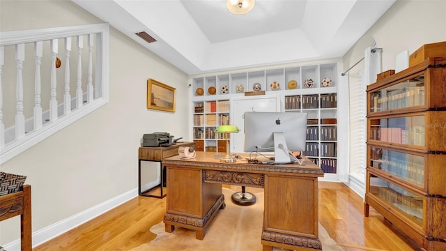 10101 Bryant Rd, Lithia, FL 33547 - home office with light wood-style flooring and a tray ceiling