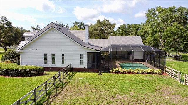 10101 Bryant Rd, Lithia, FL 33547 - back of property with a chimney, a metal roof, glass enclosure, and a patio