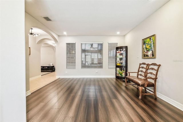 living area featuring recessed lighting, arched walkways, visible vents, and dark wood-style flooring