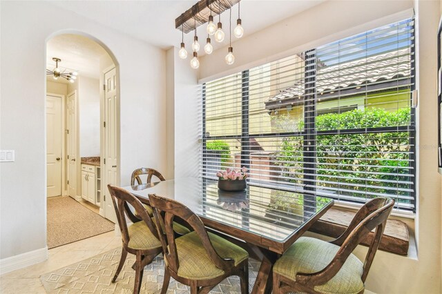 dining area with tile patterned floors, baseboards, and arched walkways