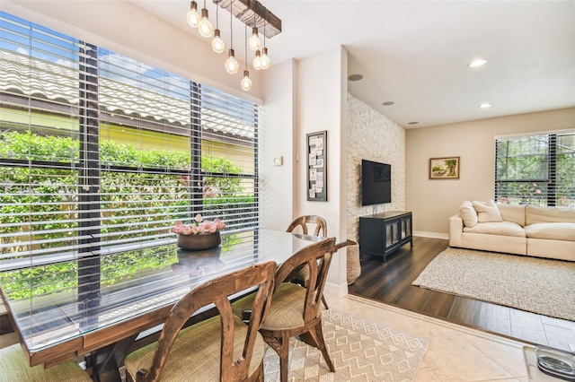 dining space with recessed lighting, a large fireplace, wood finished floors, and baseboards