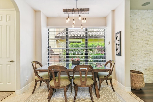 dining space featuring an inviting chandelier and arched walkways