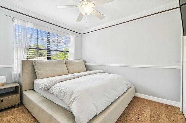 carpeted bedroom featuring ornamental molding, a ceiling fan, and baseboards