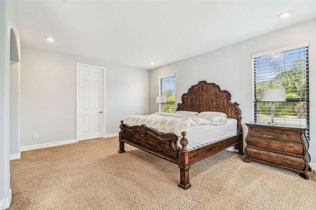 bedroom featuring recessed lighting, light colored carpet, and baseboards