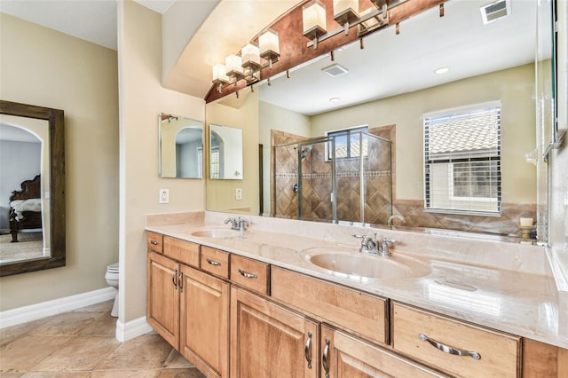 ensuite bathroom with visible vents, a shower stall, toilet, and a sink