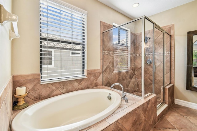 bathroom with a shower stall and a bath