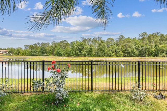 view of yard featuring a water view and fence