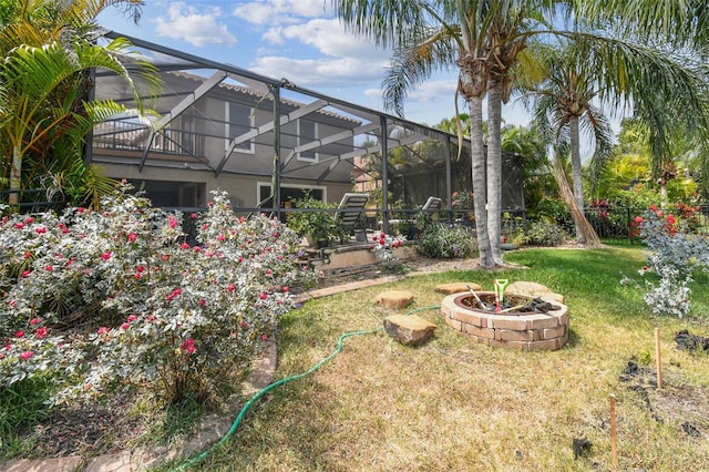 view of yard with a lanai and an outdoor fire pit