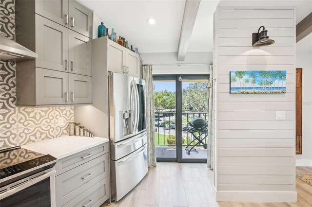 7540 Sunshine Skyway Ln S Unit 217, Saint Petersburg, FL 33711 - kitchen with beam ceiling, tasteful backsplash, light wood finished floors, appliances with stainless steel finishes, and gray cabinetry